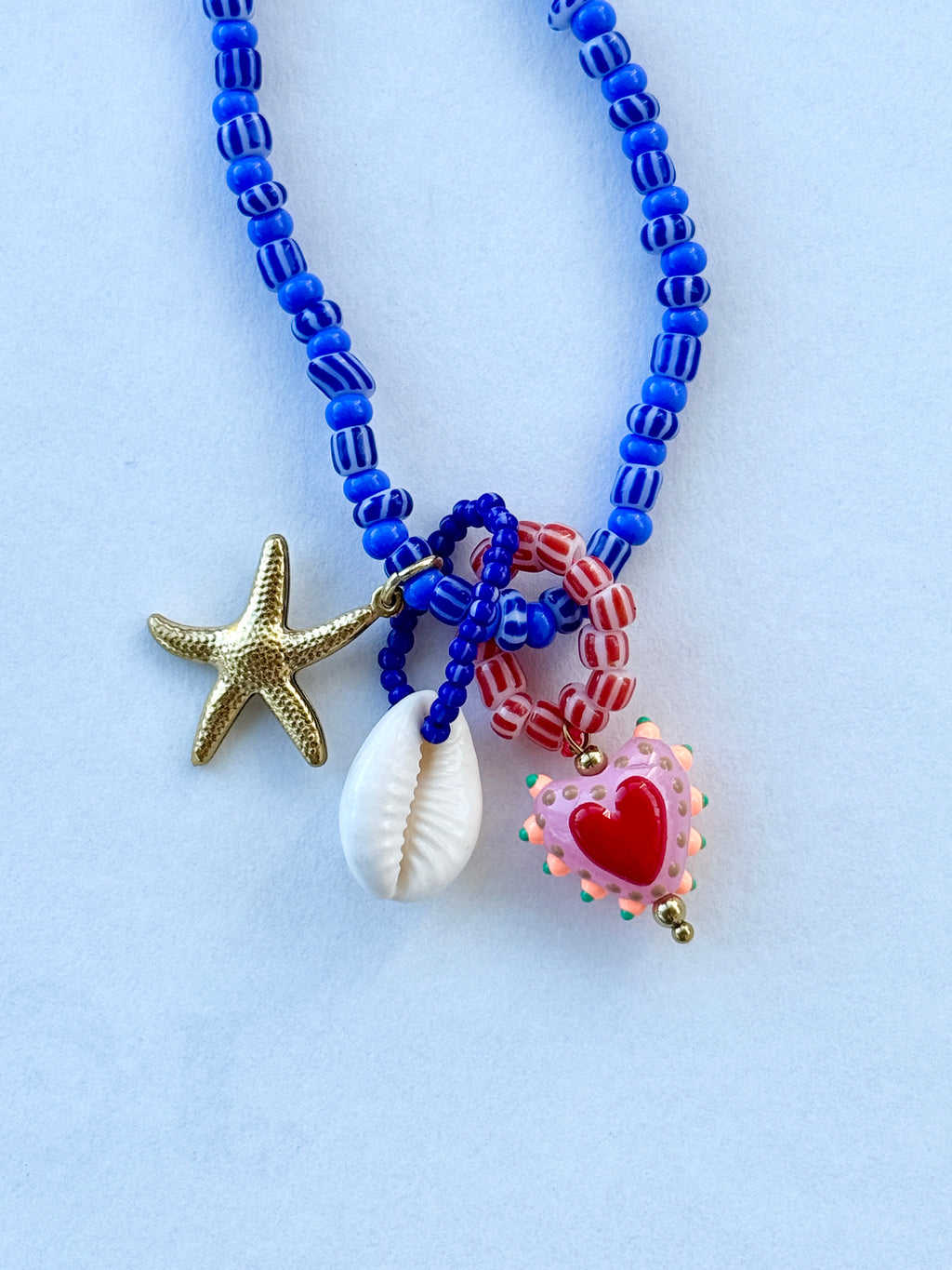 Blue beaded kjede med "Three is a charm"