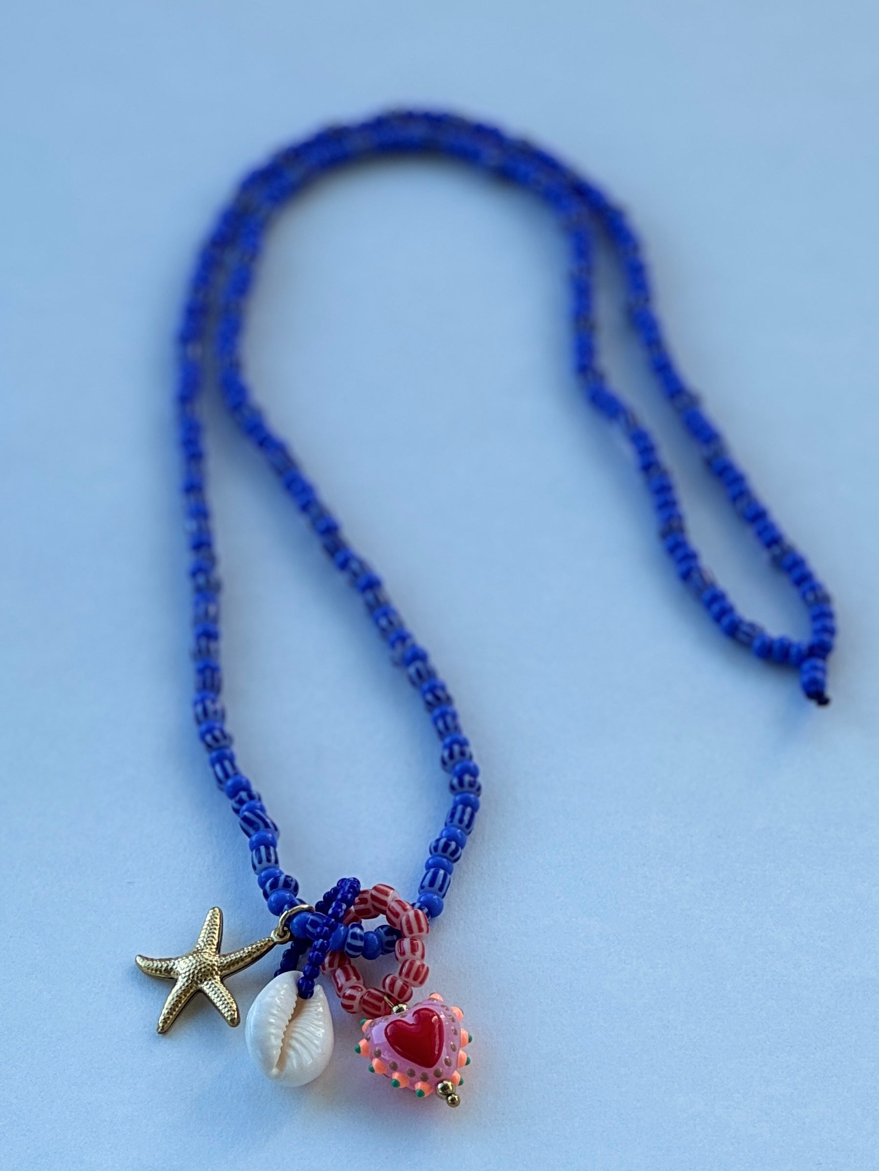 Blue beaded kjede med "Three is a charm"