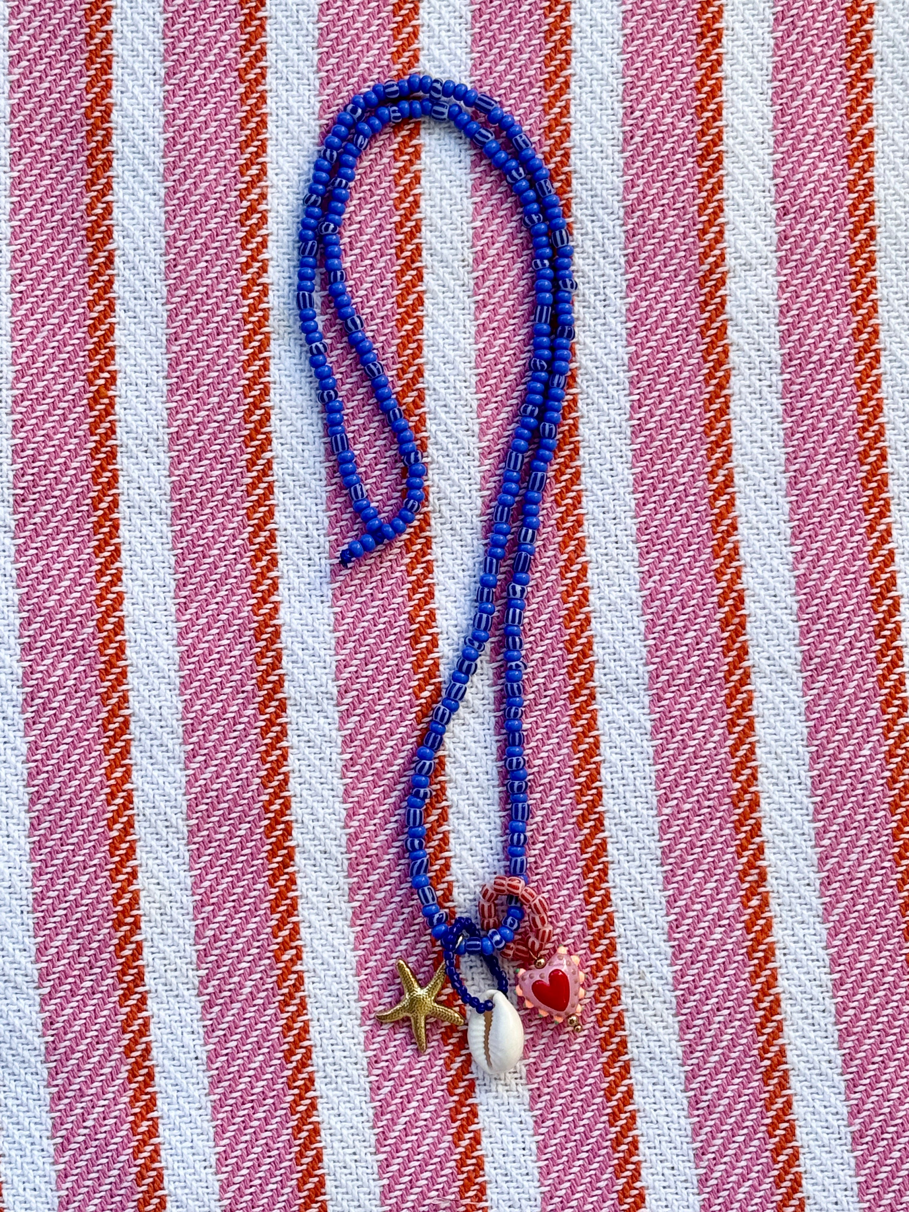 Blue beaded kjede med "Three is a charm"