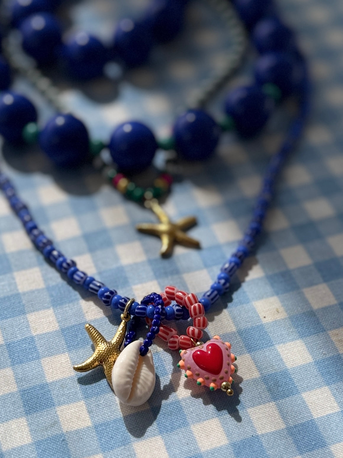Blue beaded kjede med "Three is a charm"